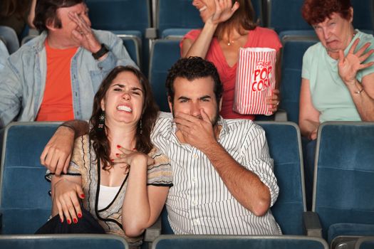 Disgusted people watch movie in a theater