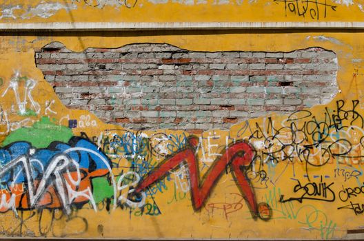 Brick wall with peeling paint and graffiti