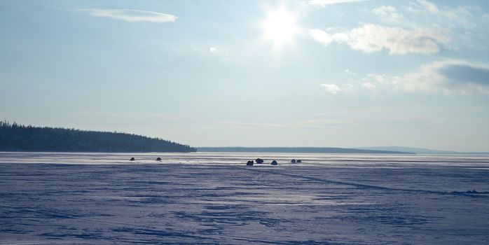 sun above frozen lake in winter