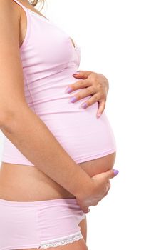 Pregnant woman is caressing her belly over white background