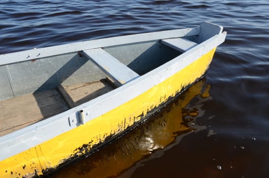 scull rowboat on dark ripple water made of wood ant tin. water transport.