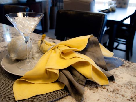 Modern place setting with martini glass, on a granite bar.