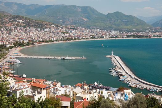 Summer vacations - blue Mediterranean sea and Turkey Alanya east coast beach resort with lighthouse and ship bay view from ancient mountain castle wall