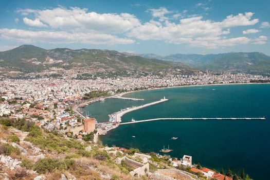 Summer vacations - blue Mediterranean sea and Turkey Alanya east coast beach resort with lighthouse and ship bay view from ancient mountain castle wall