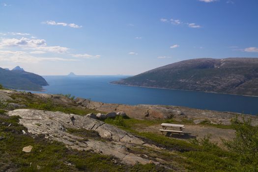 Bench for tourists high above a picturesque fjord near polar circle