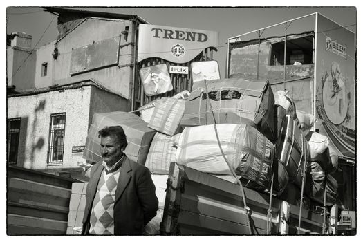 WAITING FOR DEPARTURE, ISTANBUL, TURKEY, APRIL 12, 2012: Workers loading a truck with goods in the low afternoon sun - Istanbul, Turkey.