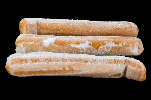 Picture of three frozen hot dogs on black