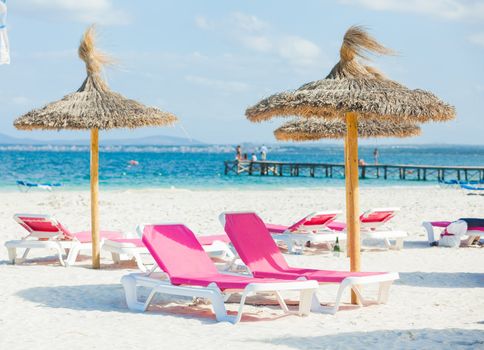 View of two chairs and umbrella on the beach.