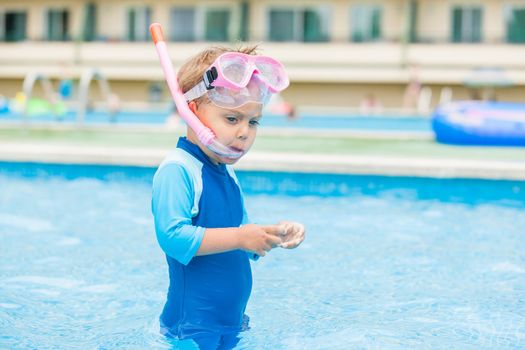 Boy playing in a pool of water during the summer