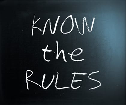 "Know the rules" handwritten with white chalk on a blackboard.
