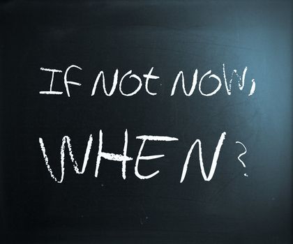 "If not now, when?" handwritten with white chalk on a blackboard.
