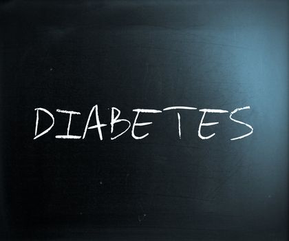 "Diabetes" handwritten with white chalk on a blackboard.
