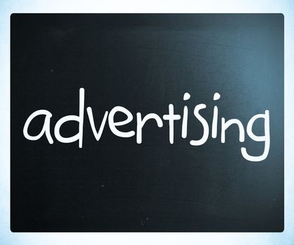 The word "advertising" handwritten with white chalk on a blackboard