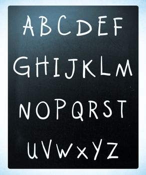 Complete english alphabet handwritten with white chalk on a blackboard