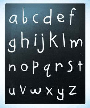 Complete english alphabet handwritten with white chalk on a blackboard