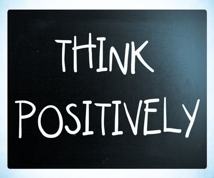 "Think Positively" handwritten with white chalk on a blackboard
