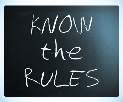 "Know the rules" handwritten with white chalk on a blackboard.