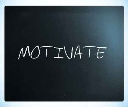 "Motivate" handwritten with white chalk on a blackboard.