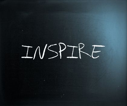"Inspire" handwritten with white chalk on a blackboard.