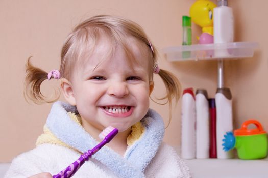 Little girl showing her teeth in bathroom