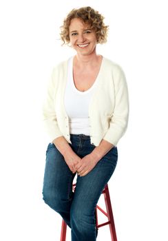 Full length view of seated senior woman isolated over white background