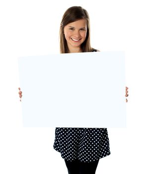 Smiling young girl showing blank placard to camera