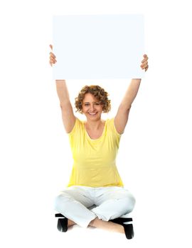 Seated woman holding blank billboard in an upward direction