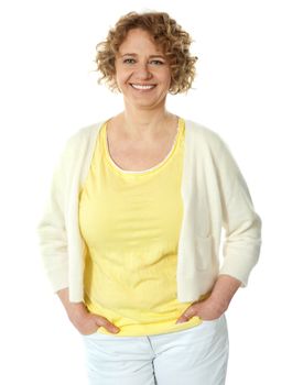 Portrait of smiling woman posing in trendy attire with hands in pocket