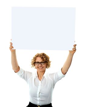 Portrait of a happy woman holding blank billboard against white background