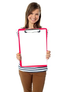 Teenager showing blank paper on clipboard to camera