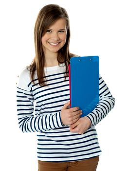 Smiling cute trendy girl holding documents and posing isolated over white