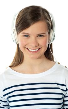 Closeup of a smiling beauty enjoying music through headphones