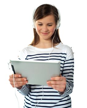 Pretty young girl enjoys listening music. Studio shot