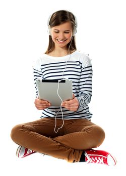 Girl watching video on her tablet with headphones attached