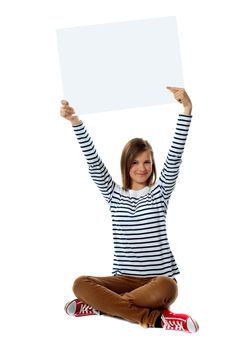 Gorgeous girl posing with blank white clipboard, seated on floor