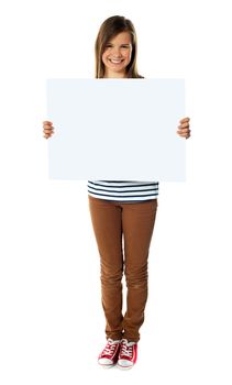 Smiling girl holding empty white board isolated over white