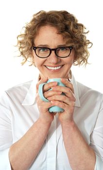 Senior business woman enjoying coffee, smiling at camera