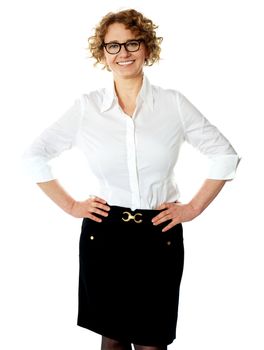 Female executive posing with hands on her waist, smiling at camera