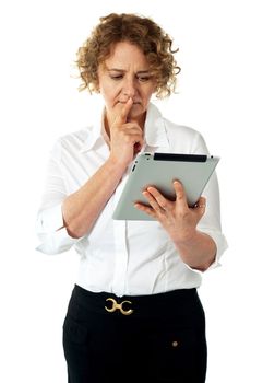 Businesswoman looking at tablet and thinking deep. Lost in thoughts