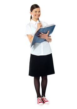 School girl thinking and smiling at camera. Holding note book