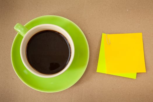 green cup of hot coffee and note paper on wood background