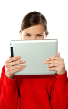 Beautiful girl hiding her face with touch pad and smiling at camera
