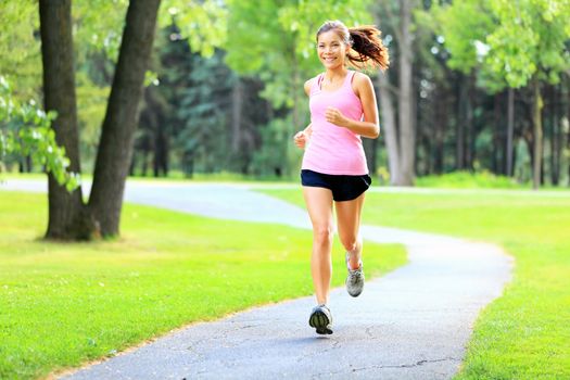 Running woman in park in summer training. Asian sport fitness model in sporty running clothes.