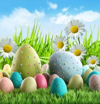 Colorful Easter eggs with daisies in the grass 