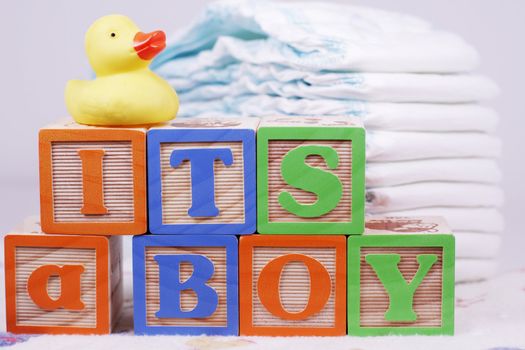 It's a boy spelled in letter blocks with rubber duck and diapers
