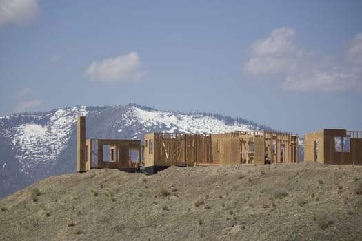 building a home on a ridge with the snowy mountains in the background