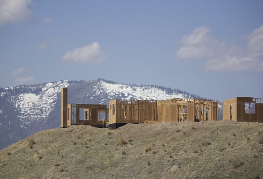 building a home on a ridge with the snowy mountains in the background