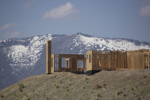 building a home on a ridge with the snowy mountains in the background