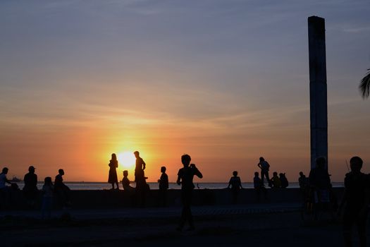 People enjoying a beautiful sunset at manila bay.