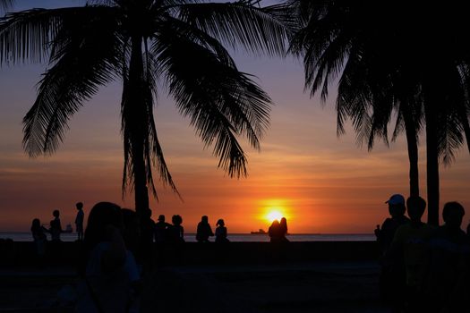crowd enjoying a beautiful sunset at manila bay.